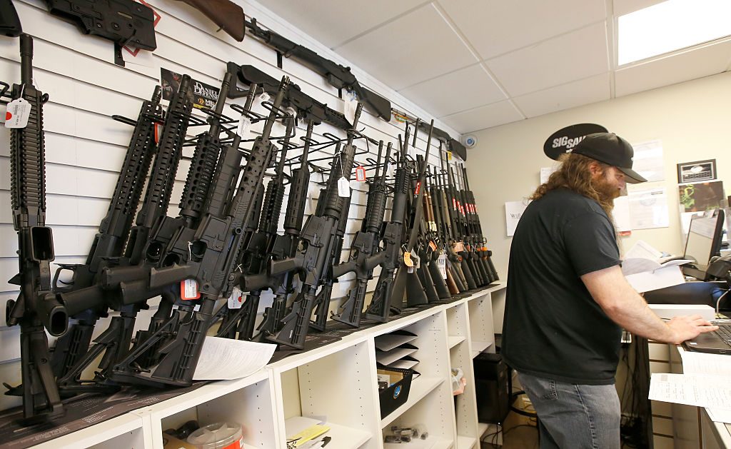 A row of guns many that are AR-15's line the wall as owner of Ready Gunman, Willy Ludlow, works on paperwork on June 17, 2016 in Springville, Utah. (Photo by George Frey/Getty Images)